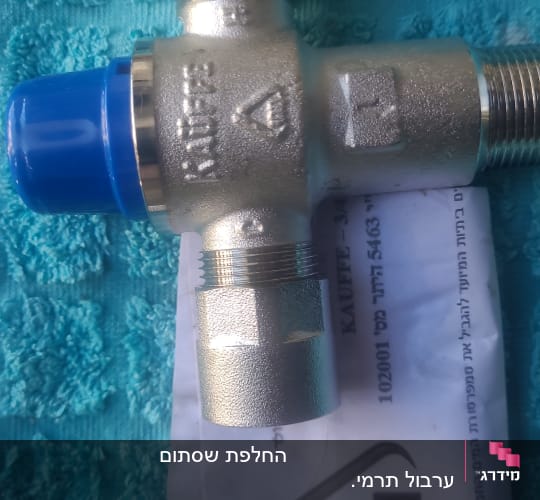 שסתום מתכת עם כיסוי כחול על רקע מגבת